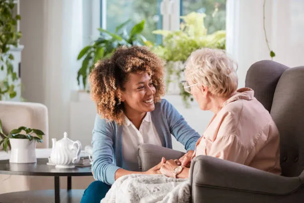 Zorgmedewerker in gesprek met een oudere cliënt